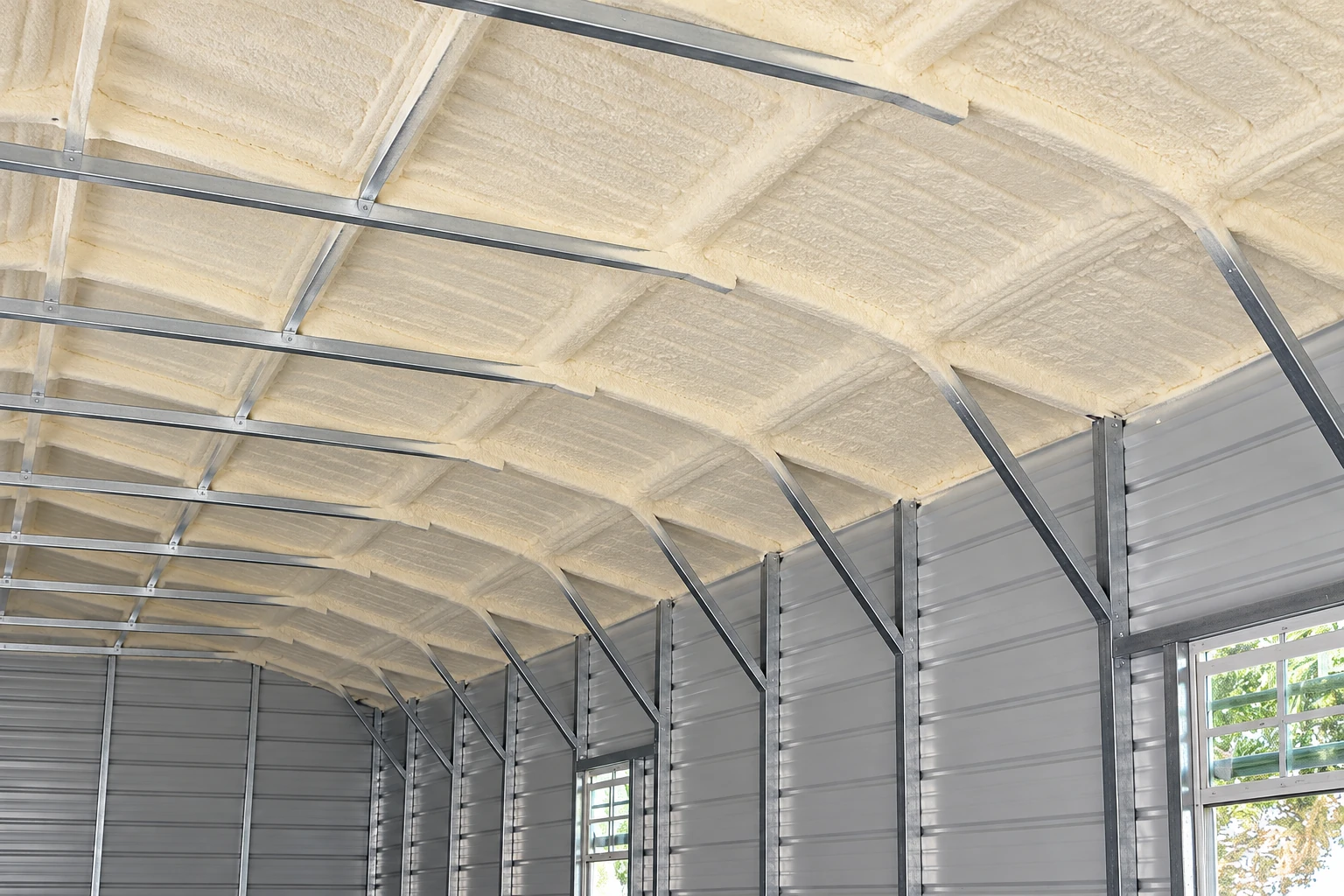 Closed-cell foam insulation coats the roof of a metal-framed building.